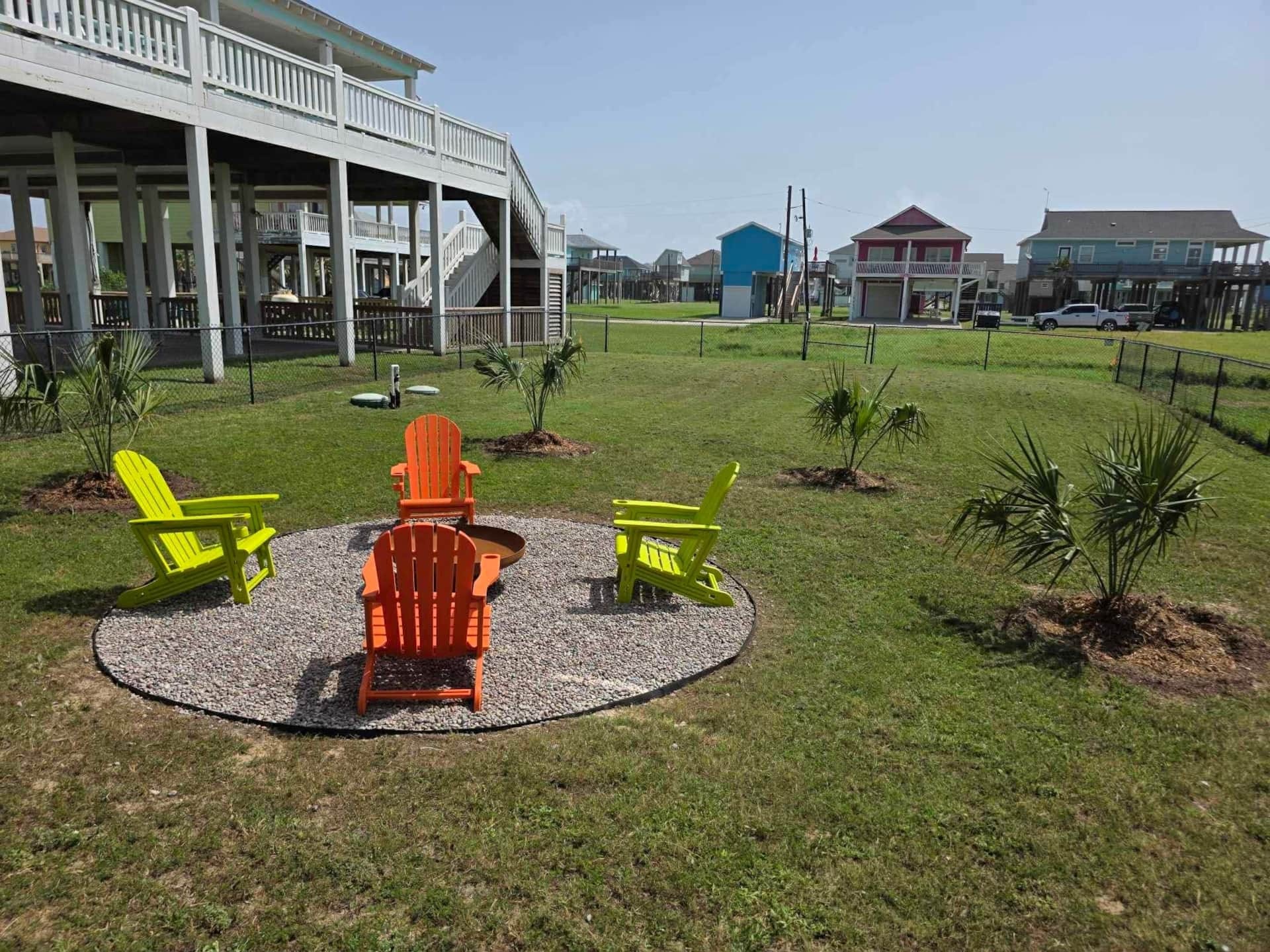 Backyard with colorful Adirondack chairs around a fire pit